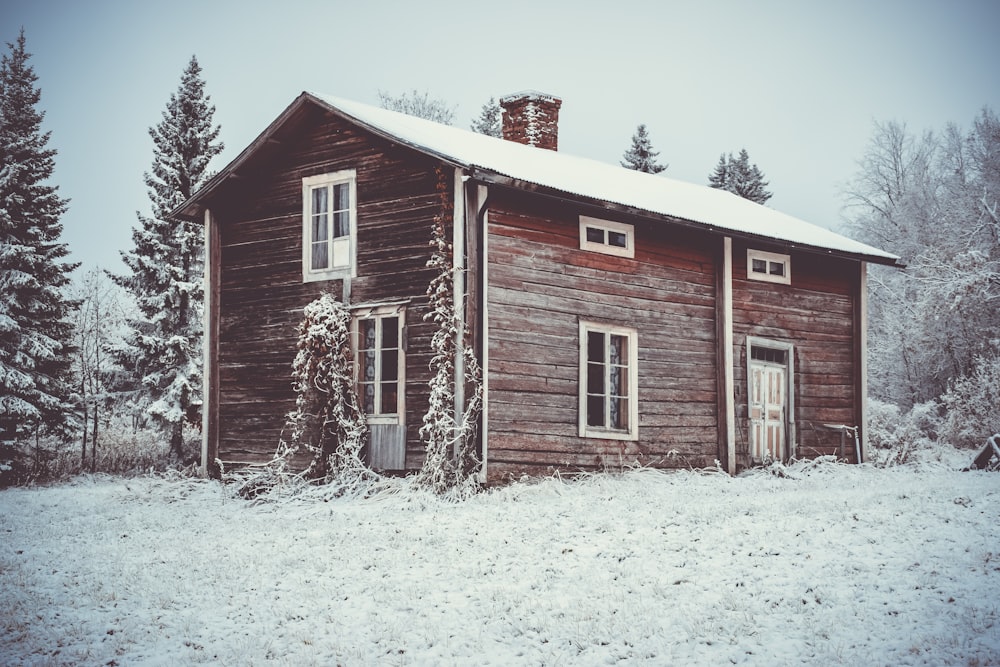 brown wooden house surrounded by snow