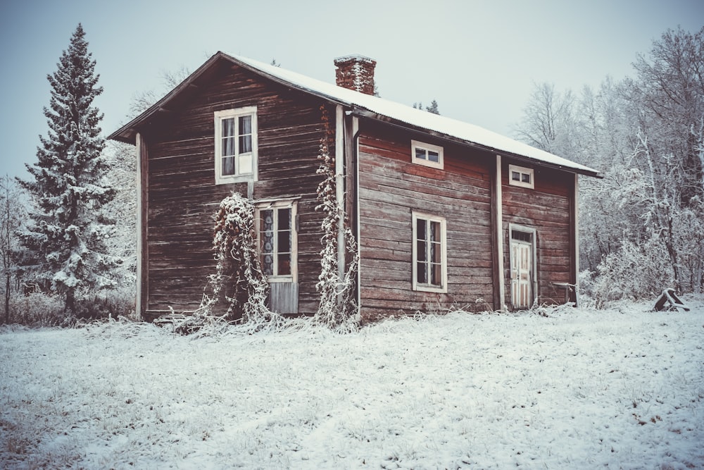 Casa de madera marrón rodeada de nieve