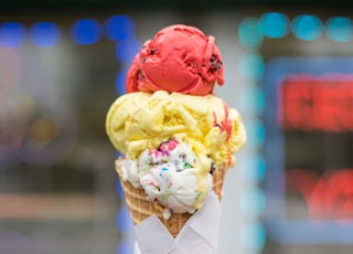macro photography of red, yellow, and white ice cream on cone