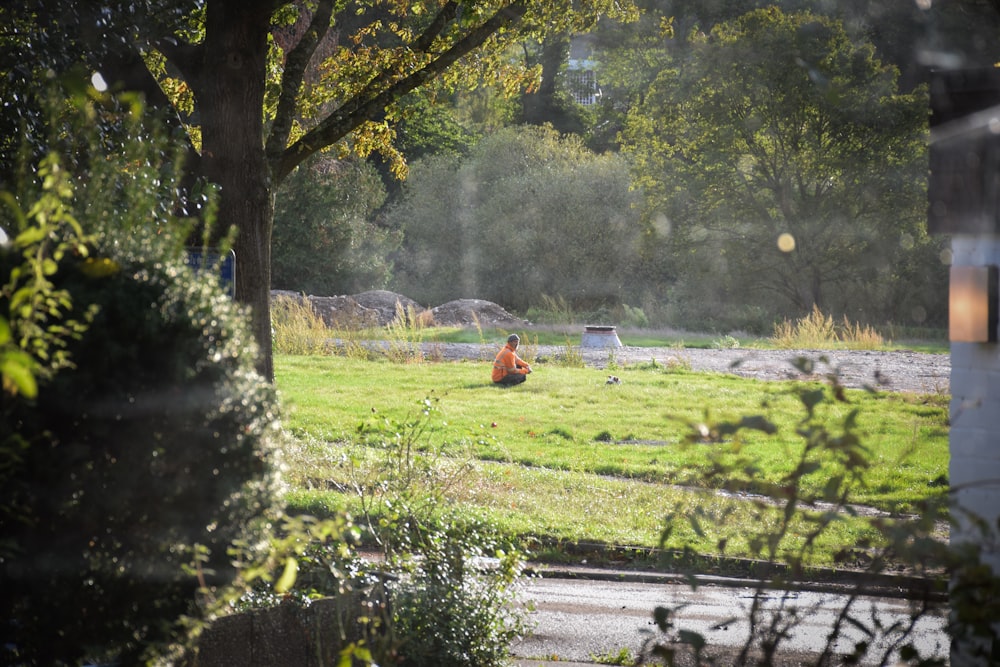 man sitting on grass field at daytime