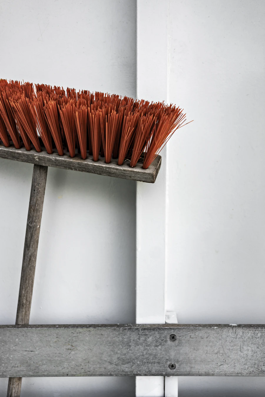 Commercial push broom leaning against a wall