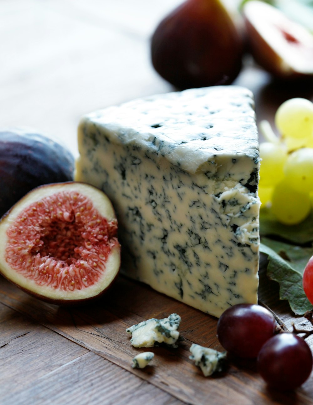 fruits and cheese on wooden surface