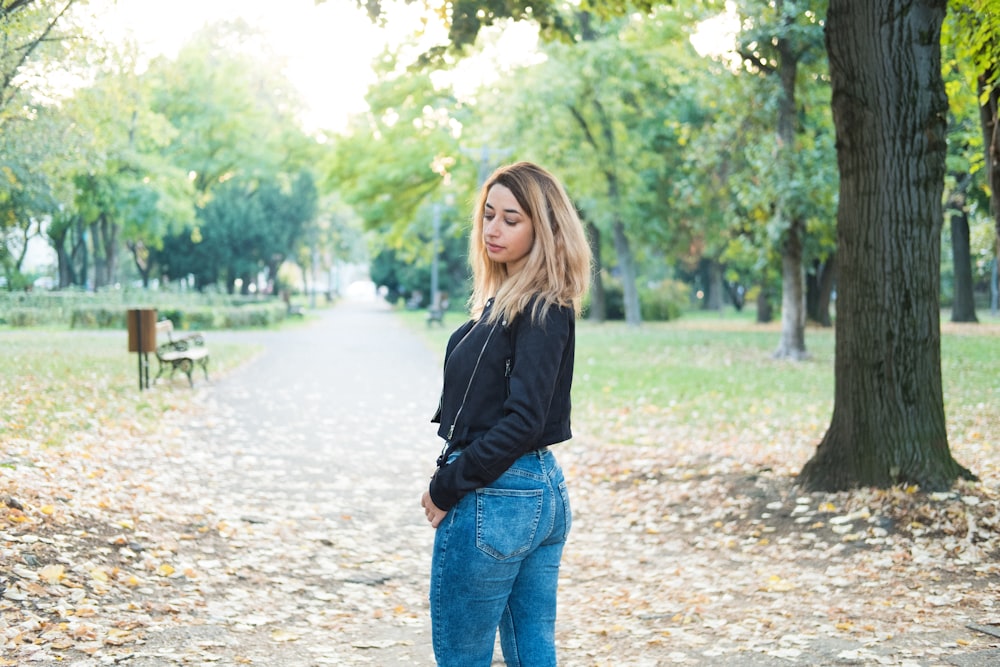 woman wearing black leather jacket and blue denim jeans