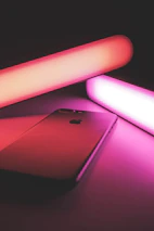Futuristic product display with sleek gadgets glowing under neon lights on a black background.