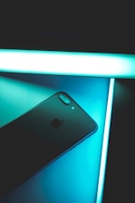 A close-up of a blue-themed icharge® device snapping onto a smartphone, glowing softly against a dark background.