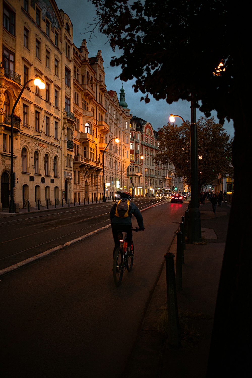 야간에 건물 옆에서 자전거를 타고 있는 남자