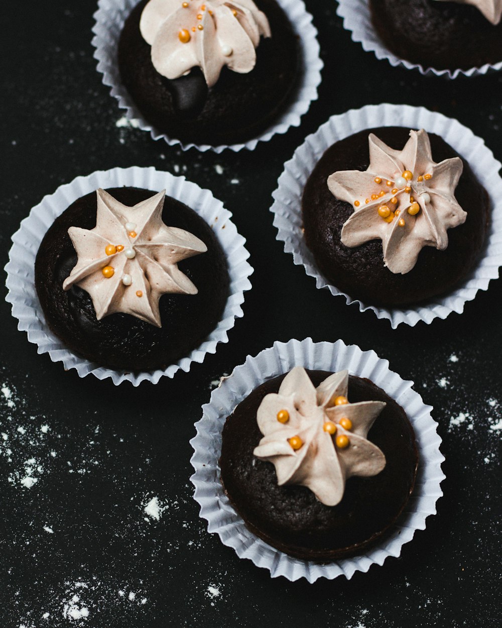 cupcakes with icings on black surface