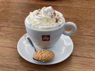 A steaming cup of traditional Brazilian coffee served with a small sweet treat on the side.