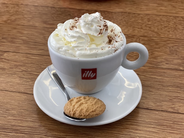 A steaming cup of traditional Brazilian coffee served with a small sweet treat on the side.