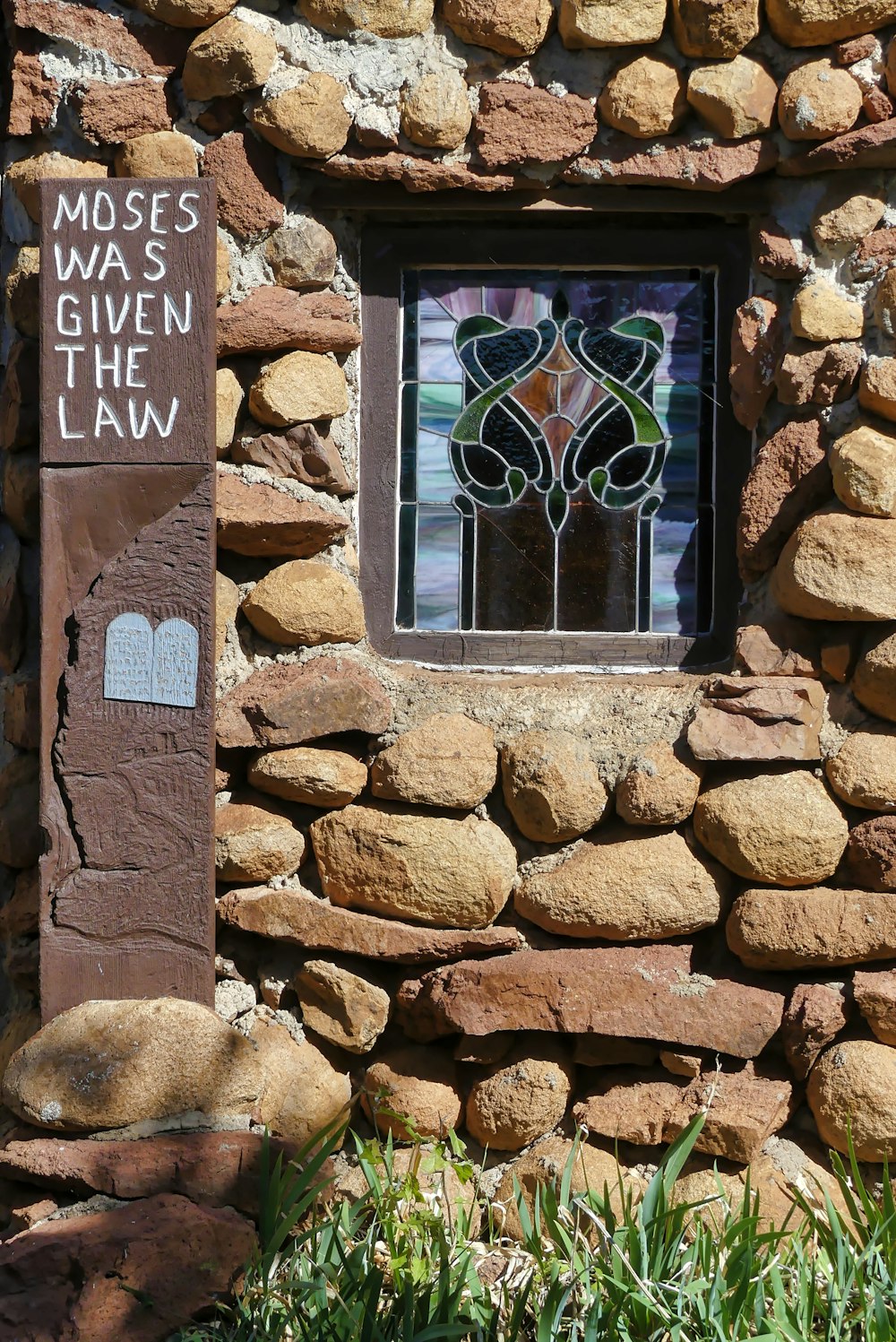 grey rock building with stained glass