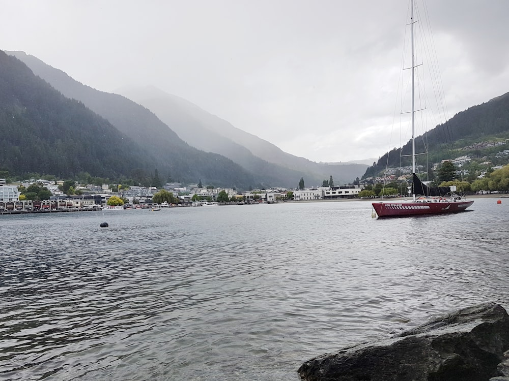 maroon boat on body of water during daytime