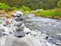 Close-up of smooth river stones stacked carefully, surrounded by lush green moss.