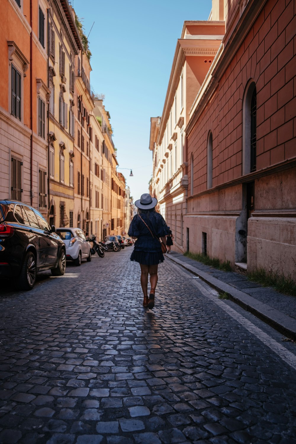 woman waling near concrete buildings