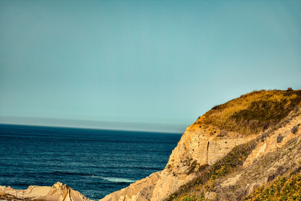 brown cliff near body of water