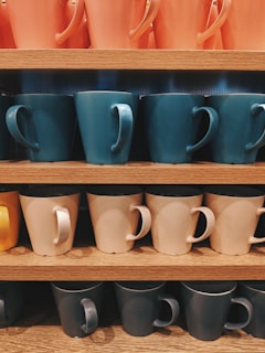 assorted-color ceramic mug lot on shelf