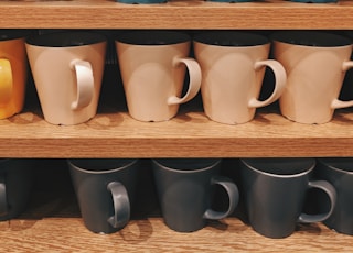 assorted-color ceramic mug lot on shelf