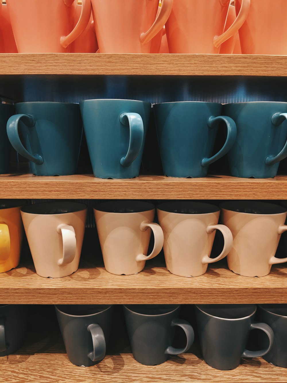 Lot de tasses en céramique de couleurs assorties sur étagère