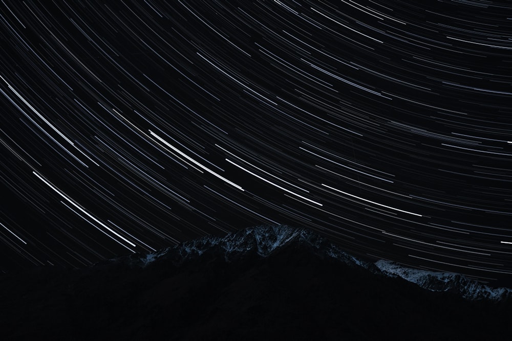 the night sky with a mountain in the background