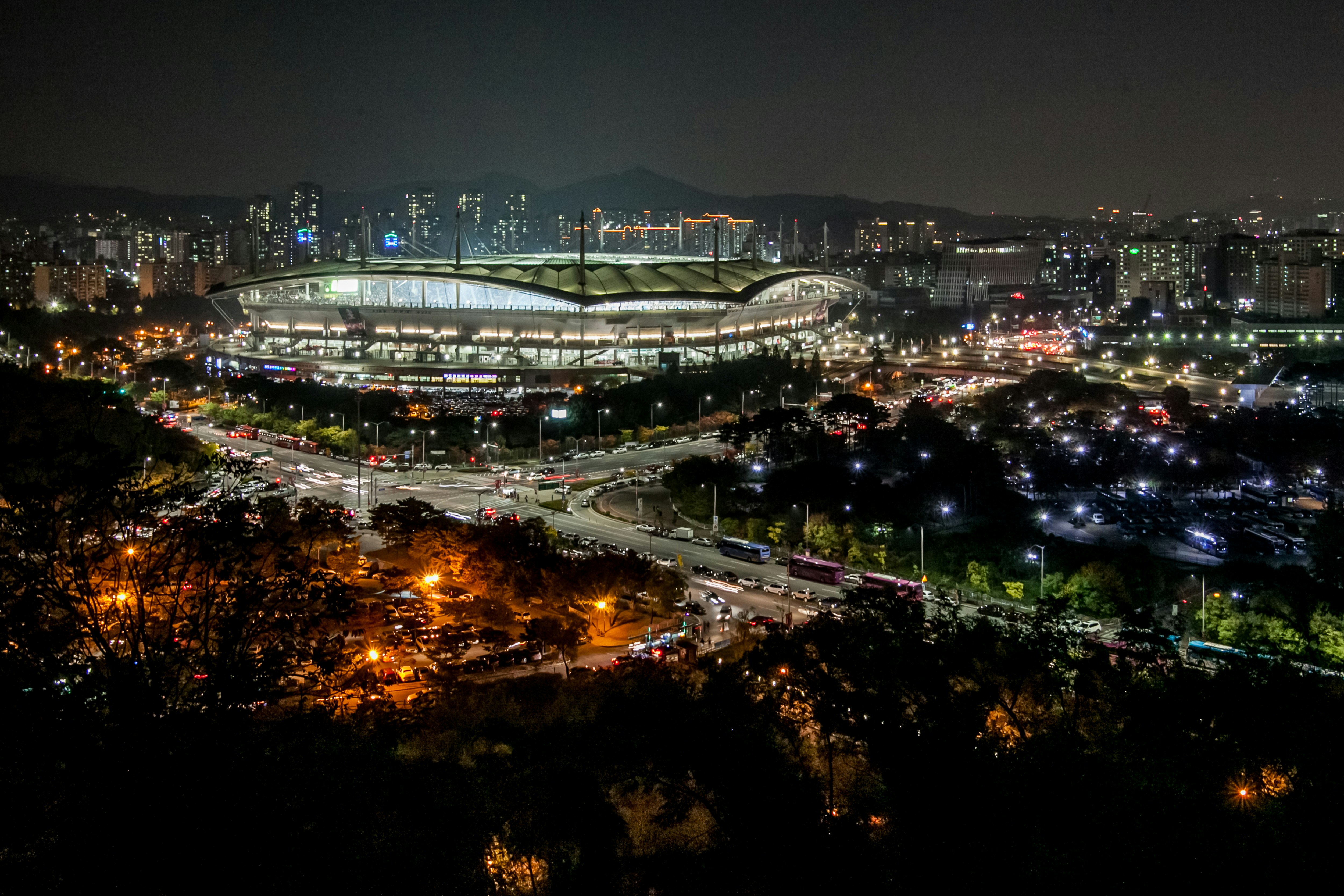 Vista aérea nocturna de un estadio lleno durante un partido