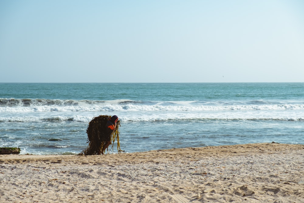 Persona de pie junto a la orilla del mar durante el día