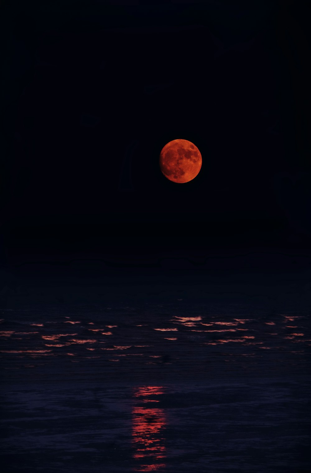 Luna roja y cuerpo de agua