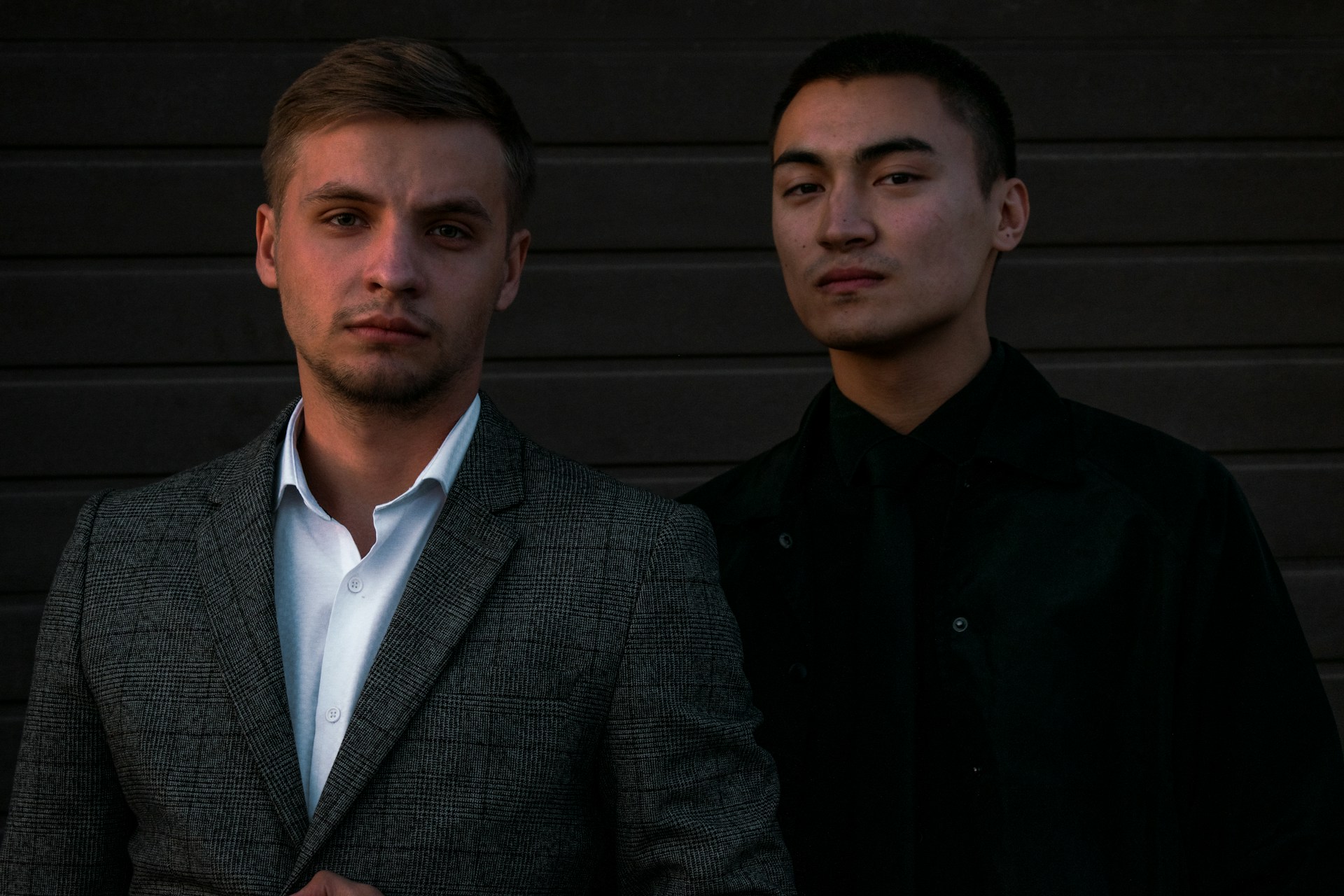 two standing men beside wall