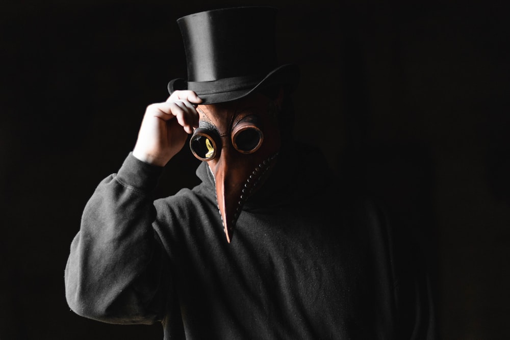 person wearing top hat and brown animal mask
