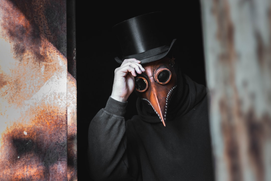 person wearing top hat and animal mask touching his hat