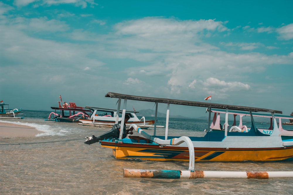 white and brown boat on shore during daytime