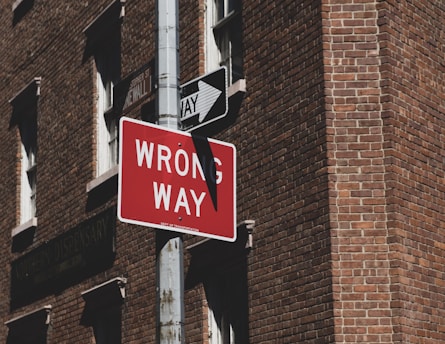wrong way road sign near building