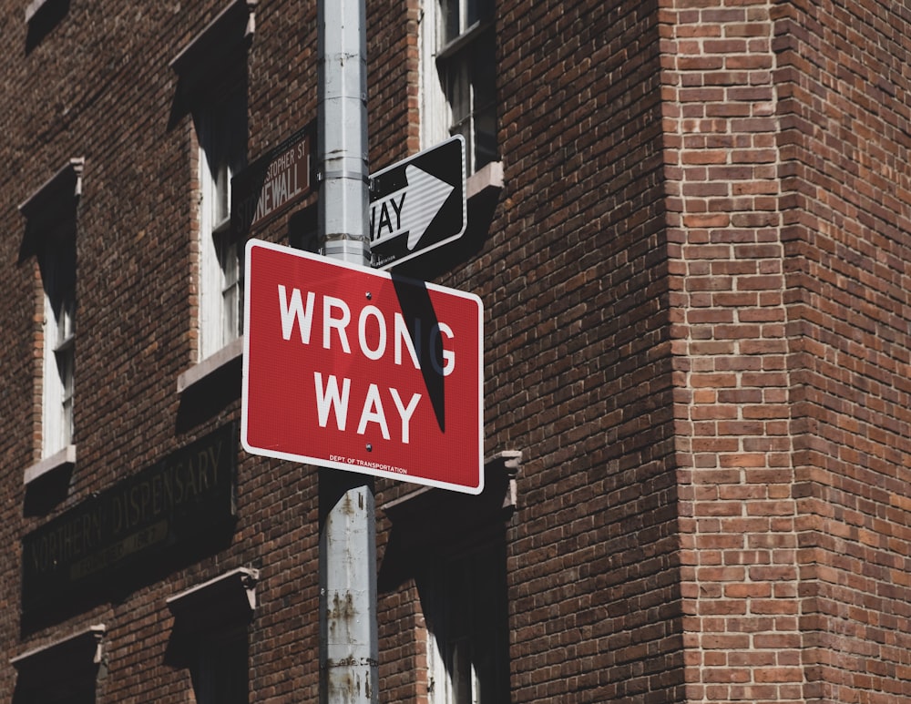 wrong way road sign near building