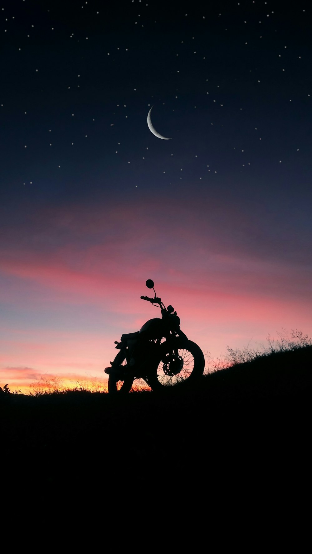 silhouette of motorcycle on grass field at night