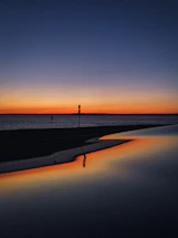 A calm, serene sunset behind a paused loading icon on a simple webpage