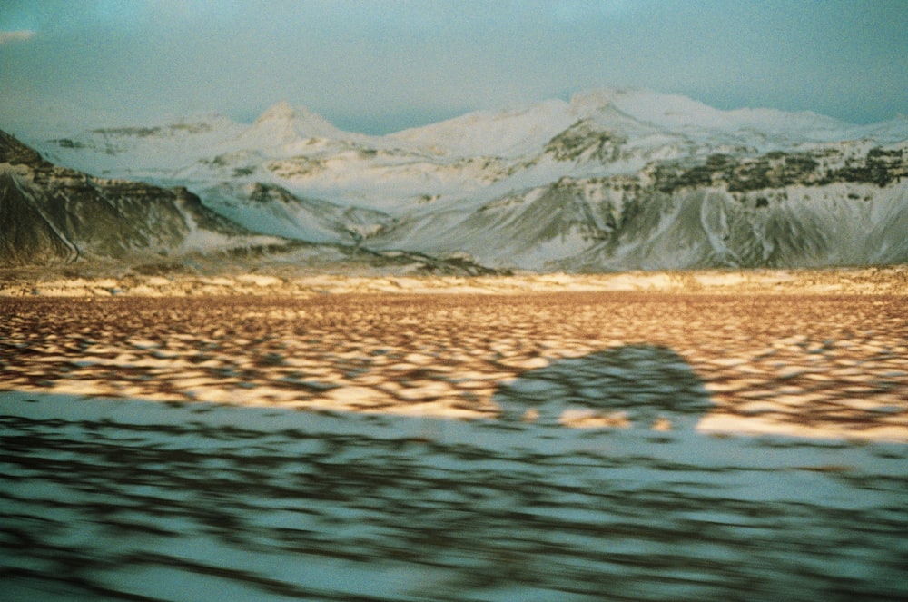 body of water near snow mountain