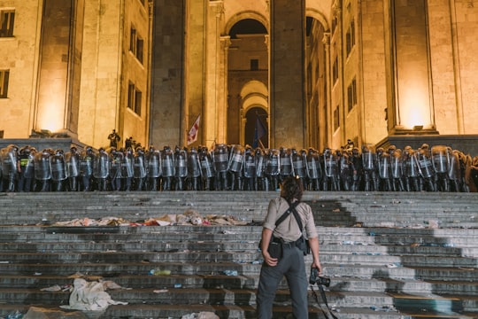 woman standing in front of group of police men in Tbilisi Georgia