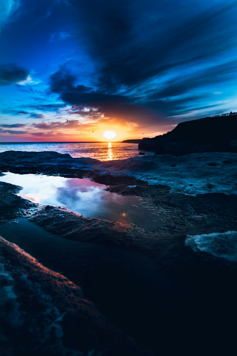 body of water near mountain during golden hour