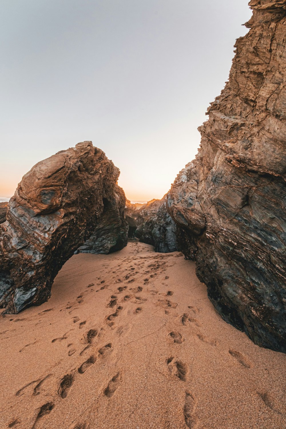 footprints in sand near rocks