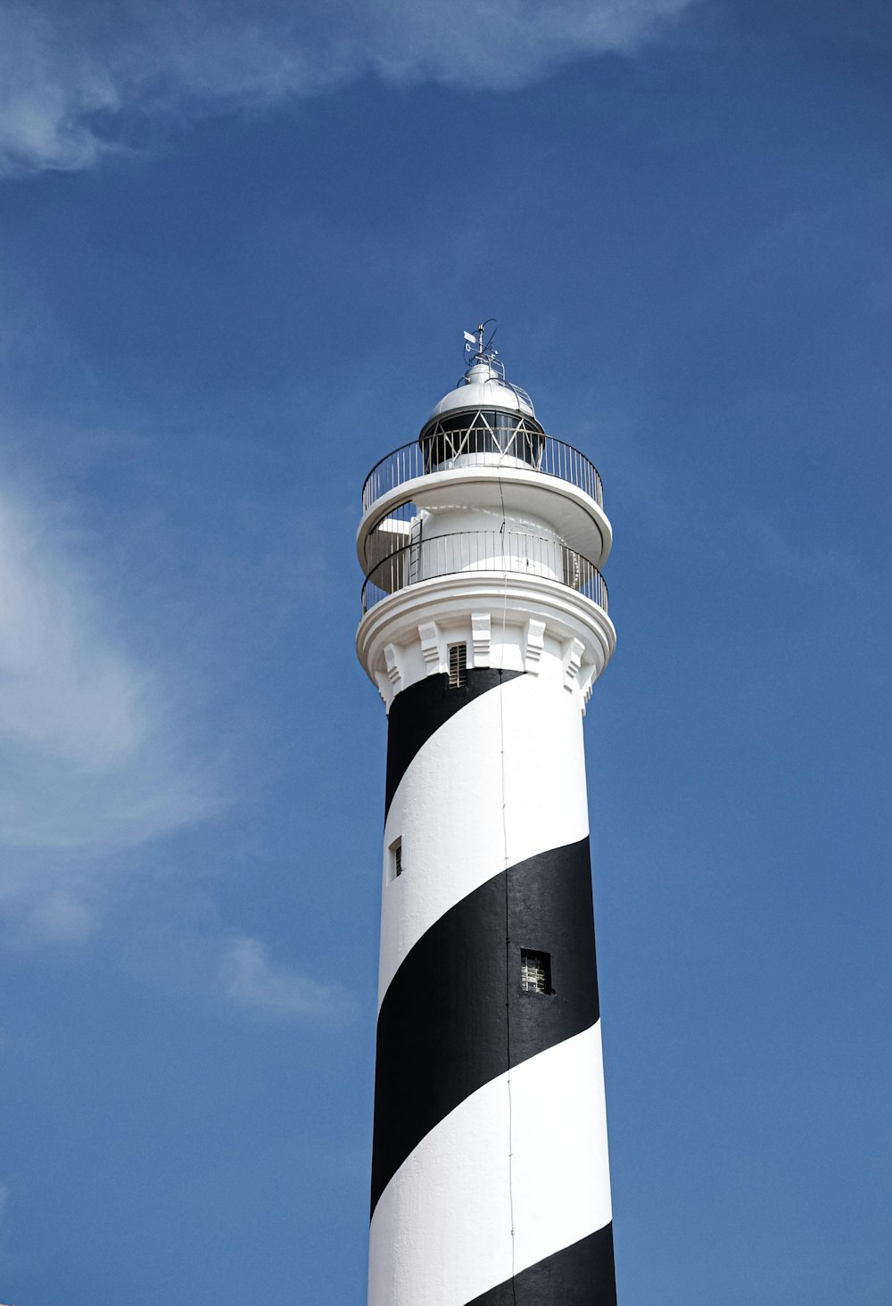 white and black lighthouse under blue sky
