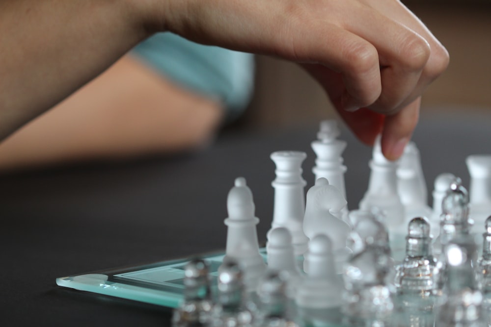 person touching chess piece