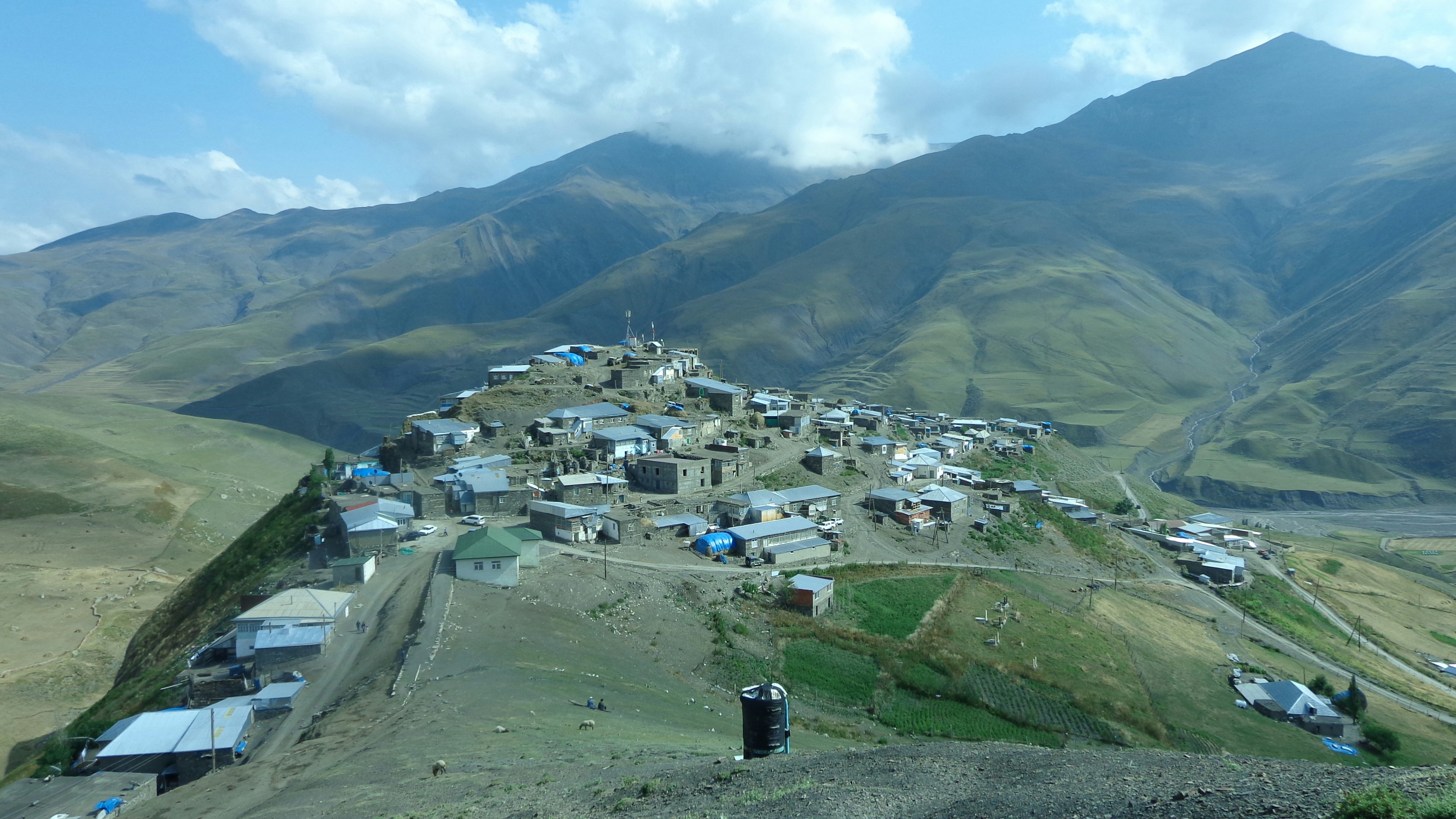 blue concrete buildings beside mountain
