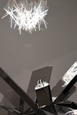 An abstract metal art piece catching light in a gallery setting.