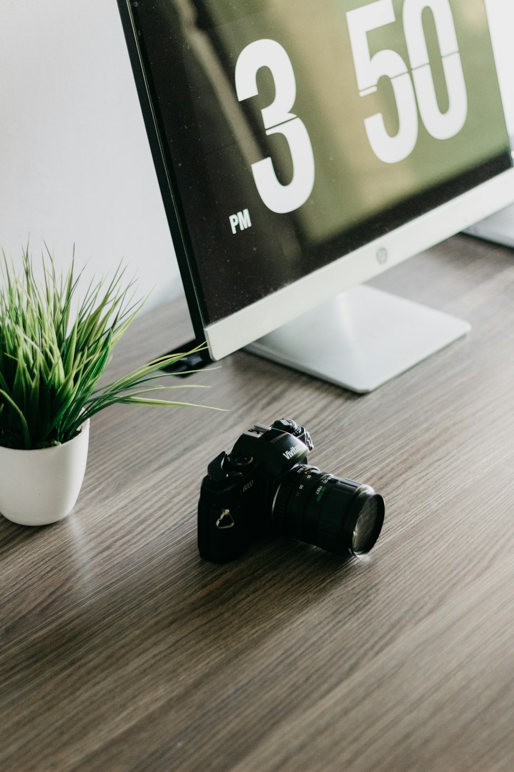 Cámara DSLR negra sobre superficie de madera marrón