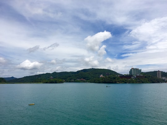 calm body of water with the distance of mountain under white and blue clouds in Xiangshan Scenic Outlook Taiwan