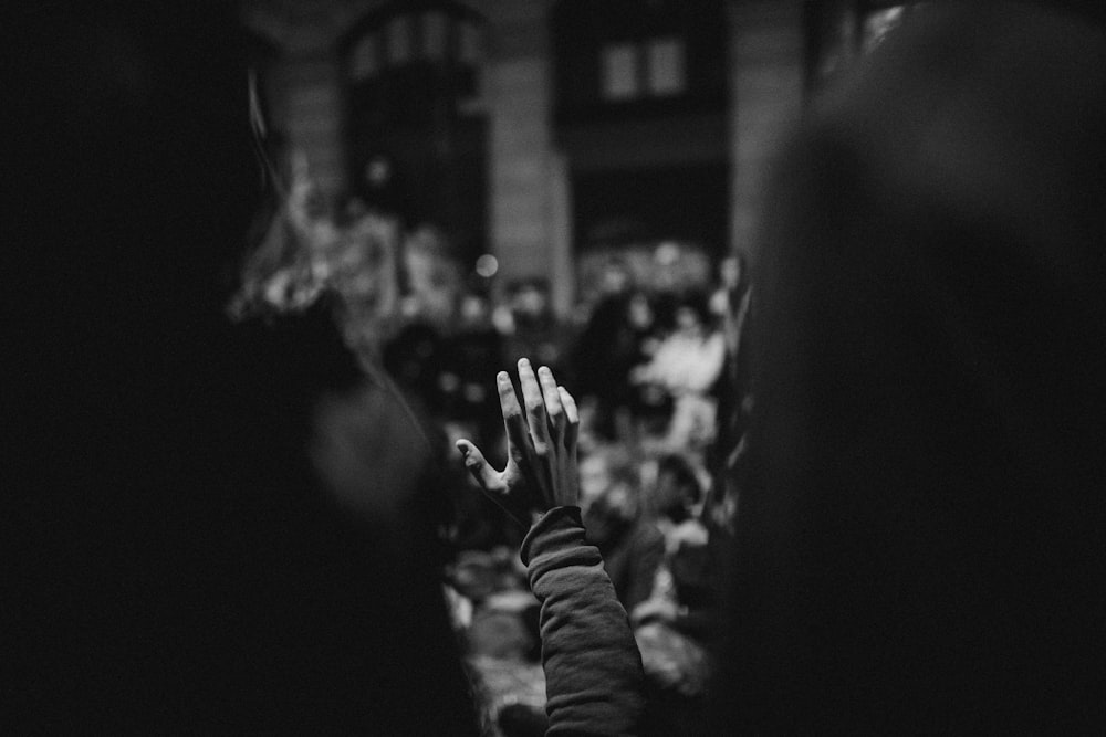 a black and white photo of a person's hand in the air