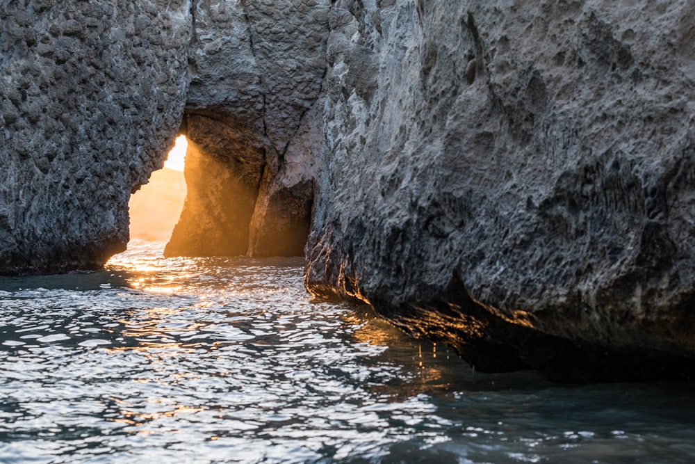 formazione rocciosa grigia e nera vicino allo specchio d'acqua