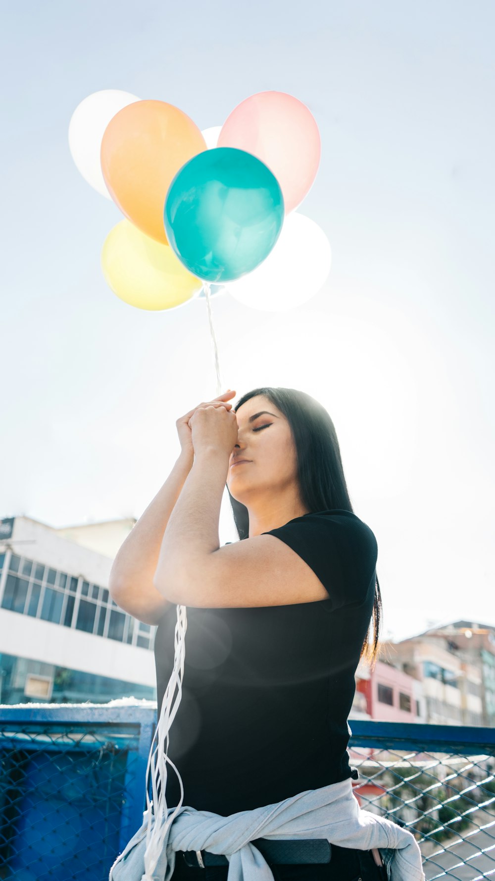 woman in black top holding balloons