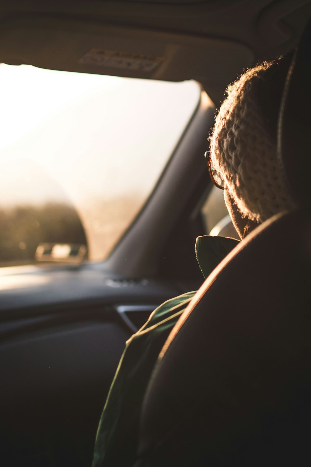 a person sitting in a car looking out the window