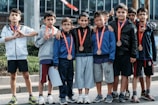 group of children wearing medal standing near wall