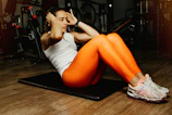 ZoomGym instructor demonstrating a powerful crunch move with a bright, bold background.