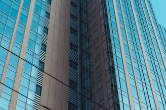 Sleek commercial office building with reflective glass windows in a bustling city.